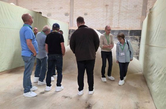 Exkursionsteilnehmer nehmen das Haufwerk in der Düngerbox in Augenschein.